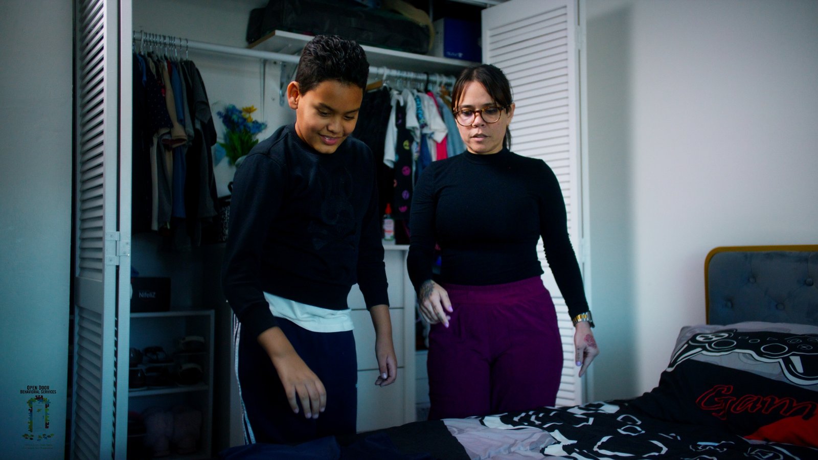 ChatGPT Plus Child with autism organizing clothes at home with their mother, using ABA strategies with professional support from Open Door Behavioral Services.